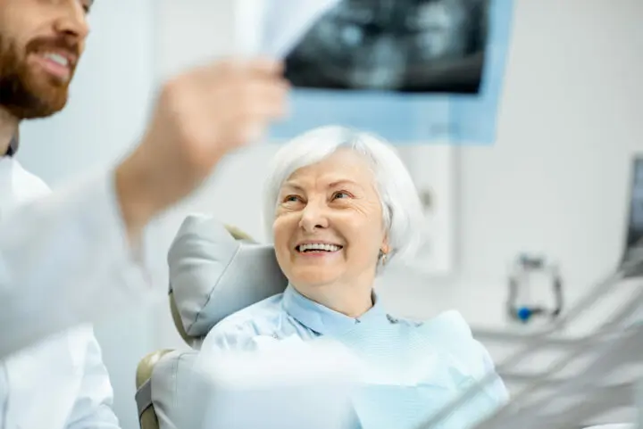 Smile in a Day™-Dentist showing x-ray to the elder woman in the dentall office
